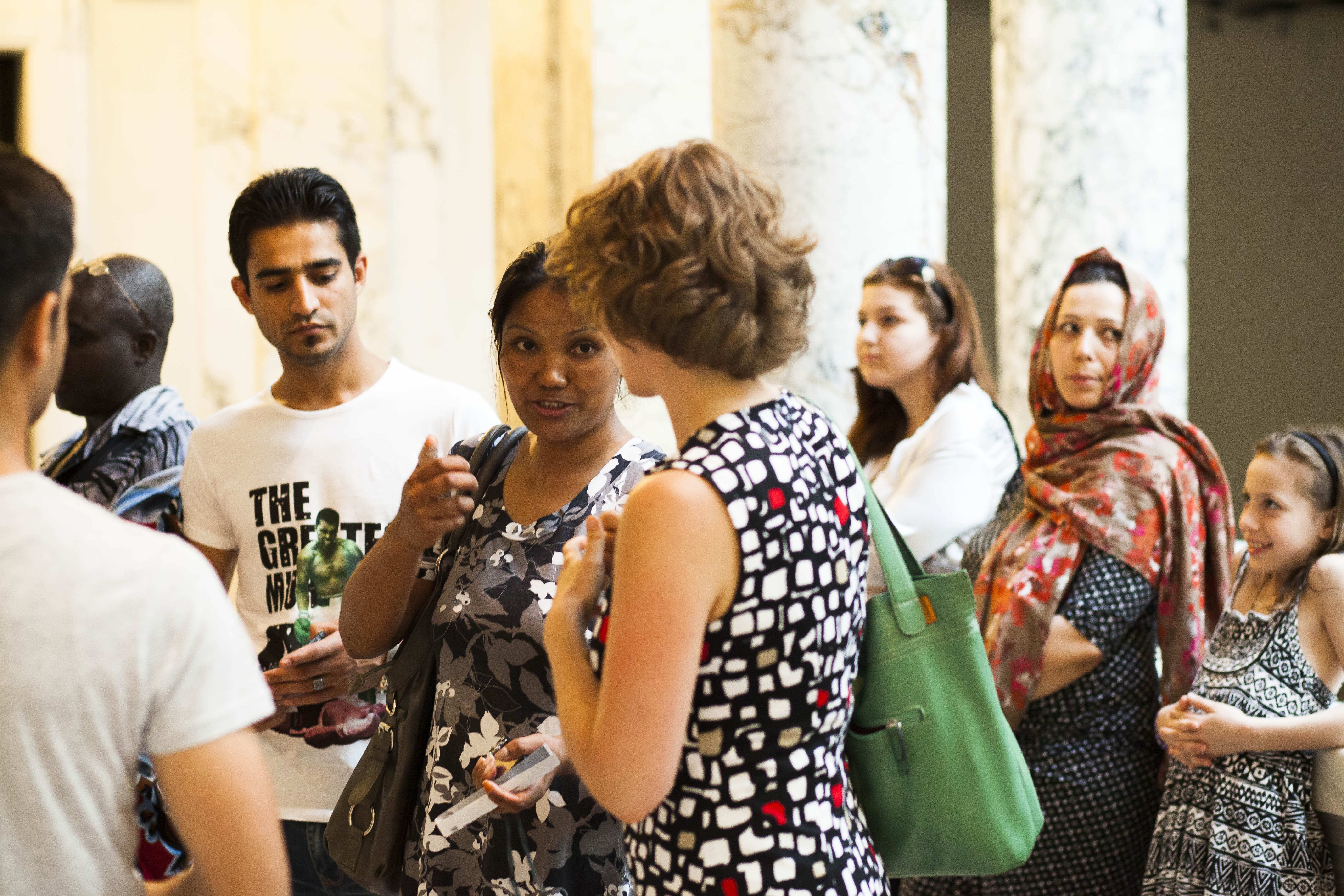 Menschen unterschiedlicher Herkunft tauschen sich bei einem Besuch im Museum aus