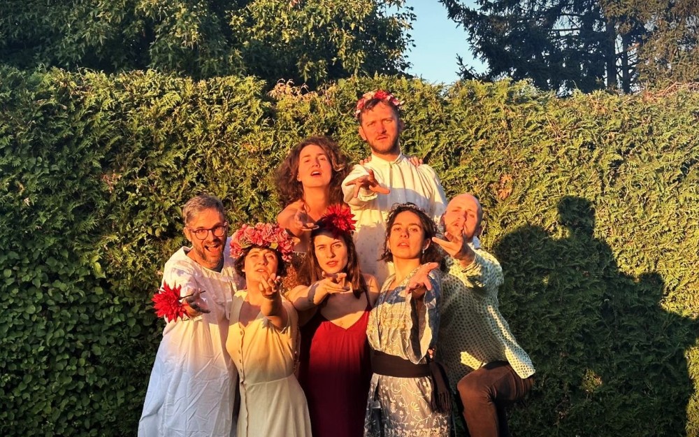 Die Theatergruppe Spielfunk posiert im Sonnenlicht vor
                                                einer Hecke.