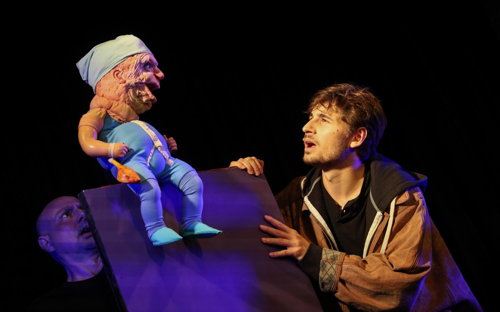 Zwei Puppenspieler und in der Mitte eine Puppe