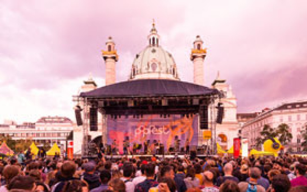 Atmosphäre vom Popfest mit Bühne und Karlskirche im
                                                Hintergrund
