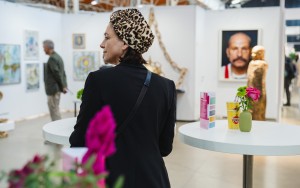 eine Frau sieht sich in der Ausstellungshalle bei der Affordable Art Fair um