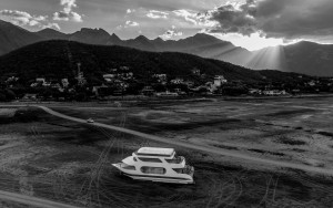 Das Bild zeigt eine s/w Fotografie von César Rodríguez. Zu sehen ist im Vordergrund ein Boot, das in einem ausgetrockneten
                                 Flussbett liegt.
